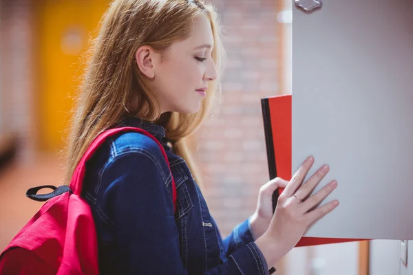 Pretty student with backpack putting notebook — Stock Photo, Image