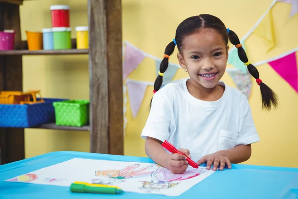 Sorrindo menina desenho em seu livro de colorir — Fotografia de Stock