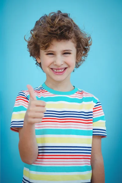 Улыбающийся мальчик, стоящий с поднятыми пальцами — стоковое фото