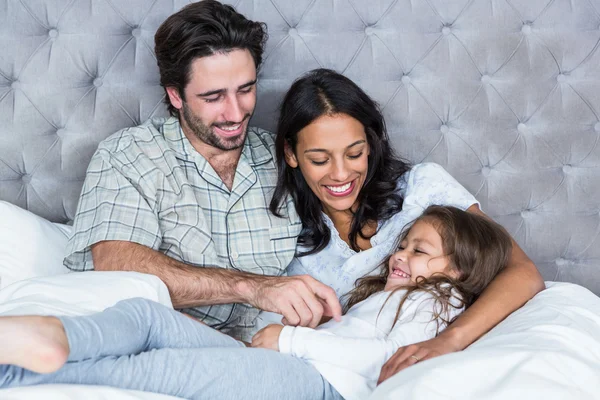 Happy parents tickling daughter — Stock Photo, Image