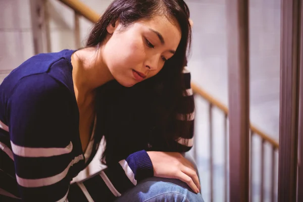 Worried student sitting in hallway — Stock Photo, Image