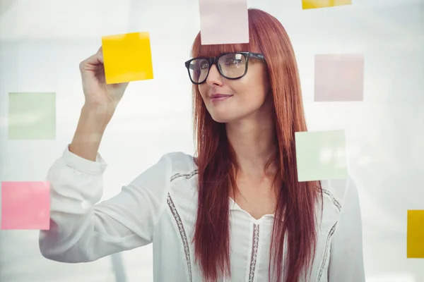 Aantrekkelijke hipster vrouw schrijven op plaknotities — Stockfoto