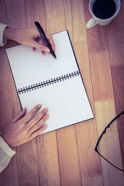 Обрезанное изображение женщины, пишущей на блокноте — стоковое фото