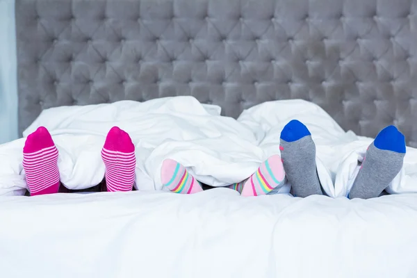 Family feet sticking out from the blanket — Stock Photo, Image