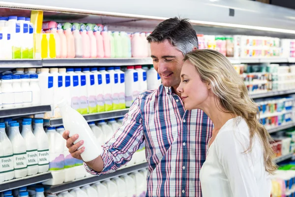 Улыбающаяся пара покупает молоко — стоковое фото