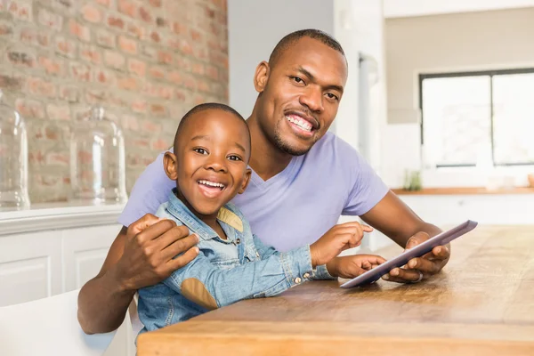 Grazioso figlio utilizzando tablet alla scrivania con il padre — Foto Stock