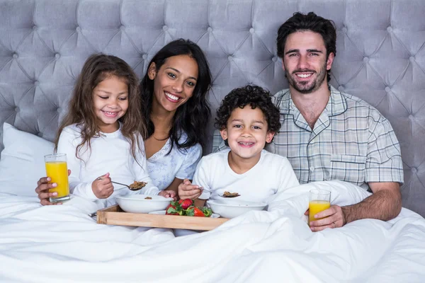 ベッドで朝食を持っている幸せな家族 — ストック写真
