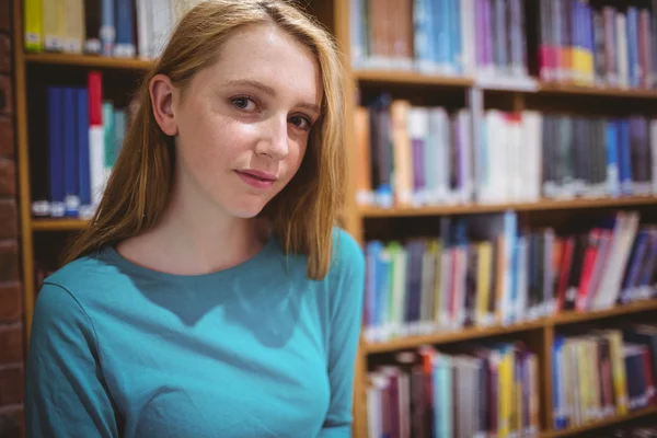 Blond student in bibliotheek kijken naar de camera — Stockfoto