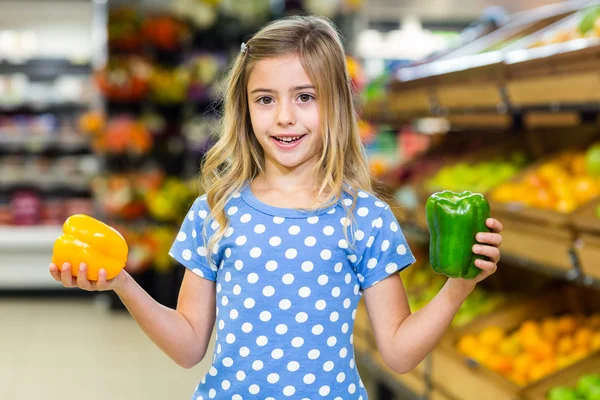 Lachende meisje houden twee peper — Stockfoto