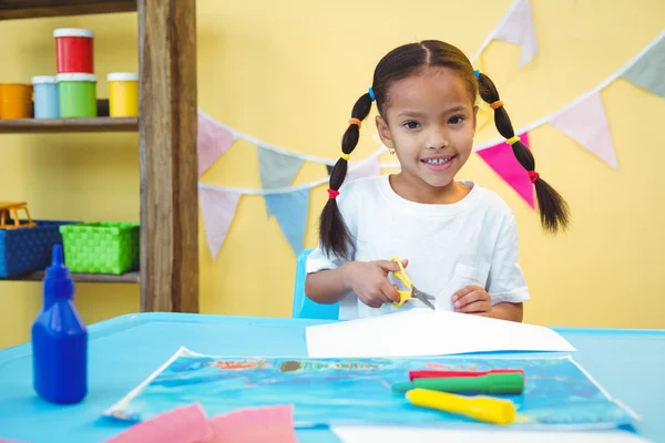 Smiling girl cut up some paper — Stock Photo, Image