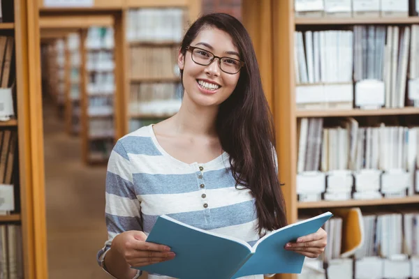 Söt student läsa en bok i biblioteket — Stockfoto