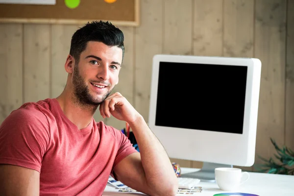 Sorrindo hipster sentado em sua mesa — Fotografia de Stock