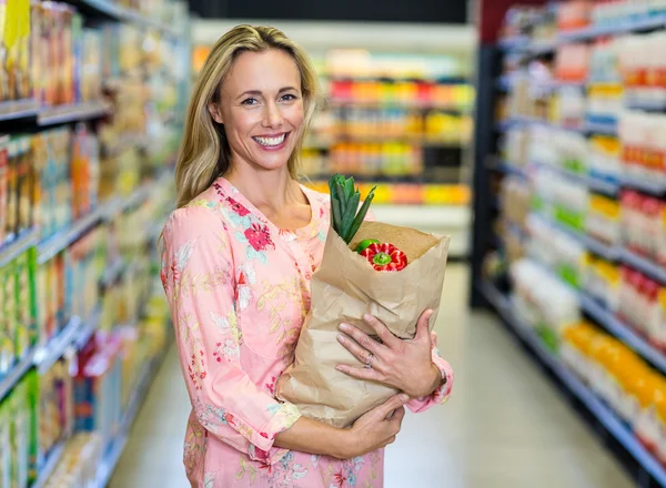 Szép, mosolygós nő gazdaság élelmiszerbolt táska — Stock Fotó