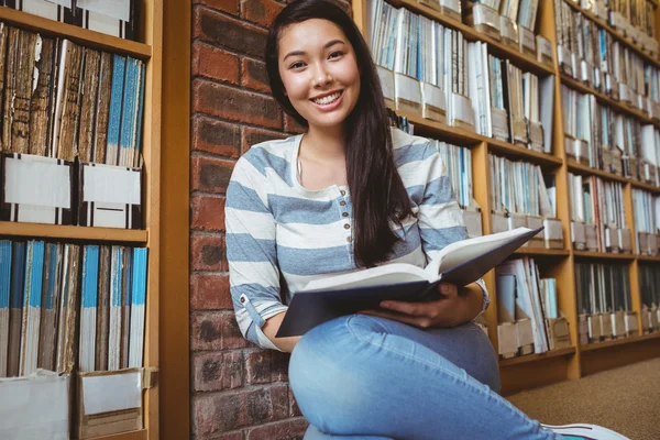 Leende student sitter på golvet — Stockfoto