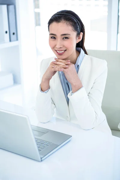 Donna d'affari sorridente utilizzando il computer portatile — Foto Stock