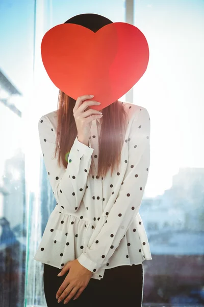 Attractive hipster woman behind a red heart — Stock Photo, Image