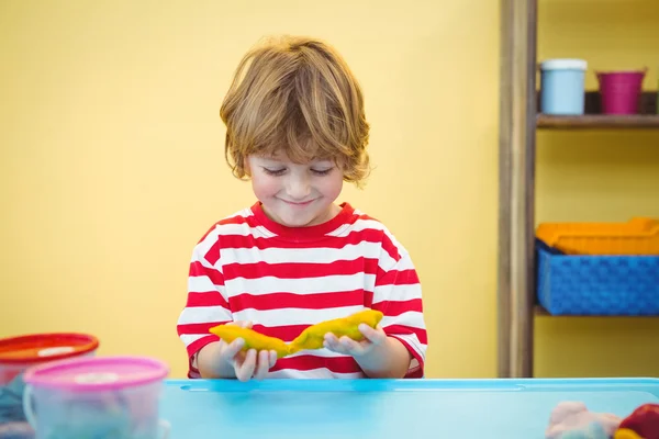 Happy boy holding modelling clay — Stock Photo, Image