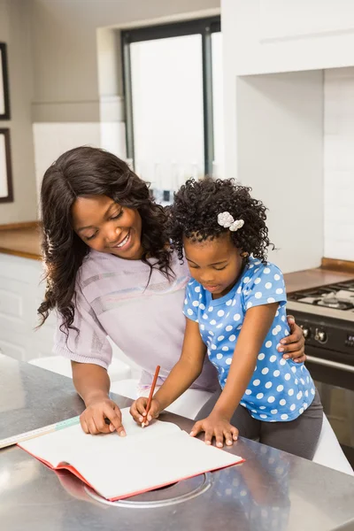 Chica joven haciendo su tarea con su madre —  Fotos de Stock