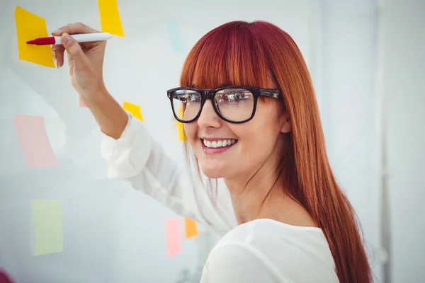 Attractive hipster woman writing on sticky notes — Stock Photo, Image