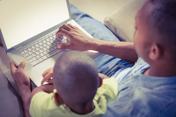 Père et fils utilisant un ordinateur portable sur le canapé — Photo