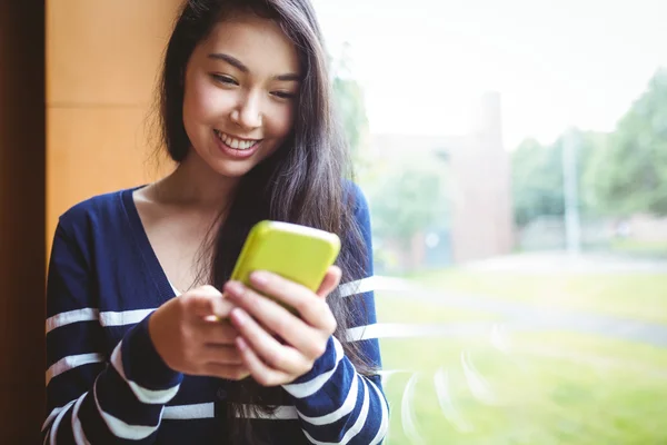 Smiling student using smartphone — Stock Photo, Image