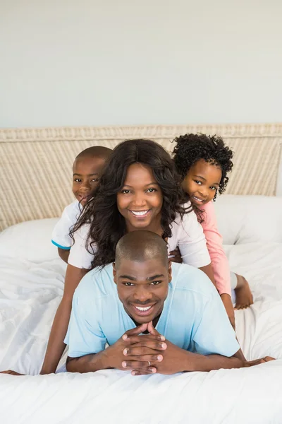 Família feliz deitada na cama — Fotografia de Stock