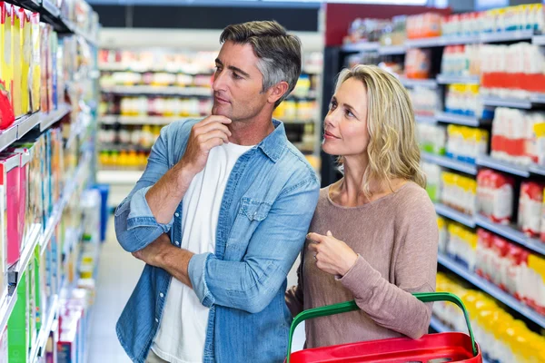 Nachdenkliches Paar wählt ein Produkt — Stockfoto