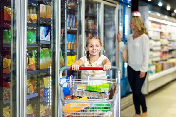 Schattig kind bedrijf winkelwagentje in de supermarkt — Stockfoto