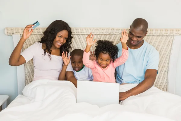 Lycklig familj handla online med laptop — Stockfoto