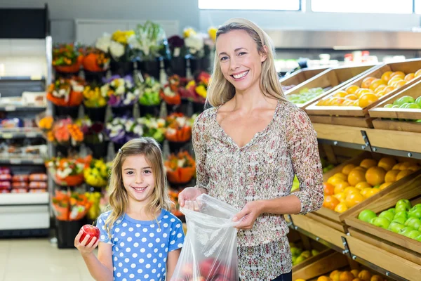 Lachende moeder en dochter plukken van apple — Stockfoto