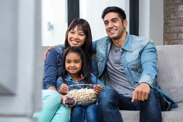 Tv를 보면서 팝콘을 먹는 행복 한 젊은 가족 — 스톡 사진