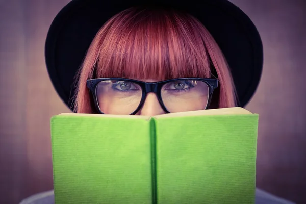 Hipster vrouw achter een groene boek — Stockfoto