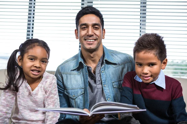 快乐的父亲为他的孩子们读一本书 — 图库照片