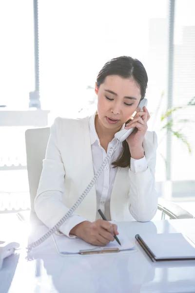 Uśmiechnięta kobieta za pomocą jej telefon — Zdjęcie stockowe