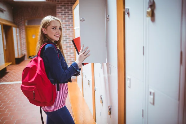 Estudante bonito com mochila colocando notebook — Fotografia de Stock