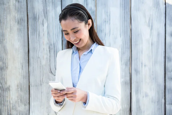 Mulher de negócios sorrindo usando smartphone — Fotografia de Stock