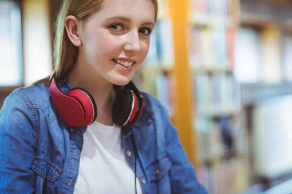 Leende student med hörlurar tittar på kameran — Stockfoto