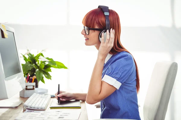 Attraente donna hipster con auricolare utilizzando tablet grafica — Foto Stock