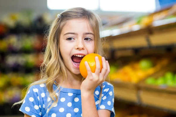 Sonriente jovencita comiendo una naranja — Foto de Stock