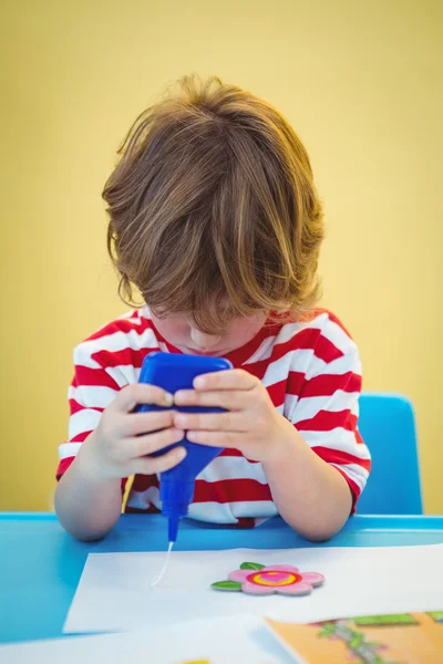 Small boy using a bottle of glue — Stock Photo, Image