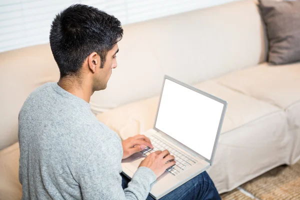 Bell'uomo che utilizza il computer portatile sul divano — Foto Stock