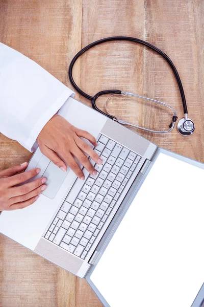Arzt mit Laptop auf Holztisch — Stockfoto