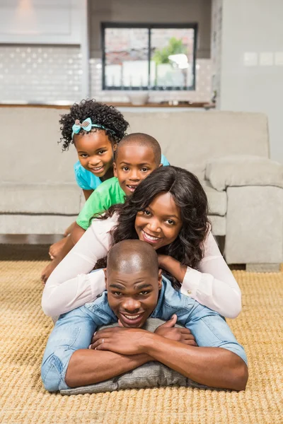 Familia feliz tendida en el suelo en casa —  Fotos de Stock