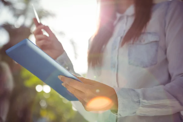 Uśmiechnięta kobieta za pomocą jej tabletki — Zdjęcie stockowe