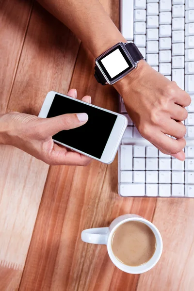 Vrouwelijke handen met smartwatch gebruikend smartphone — Stockfoto