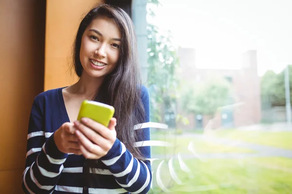 Étudiant souriant utilisant un smartphone — Photo