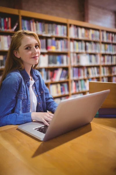 Szőke diák használ laptop-könyvtár — Stock Fotó