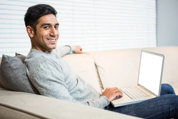 Beau homme utilisant un ordinateur portable sur le canapé — Photo