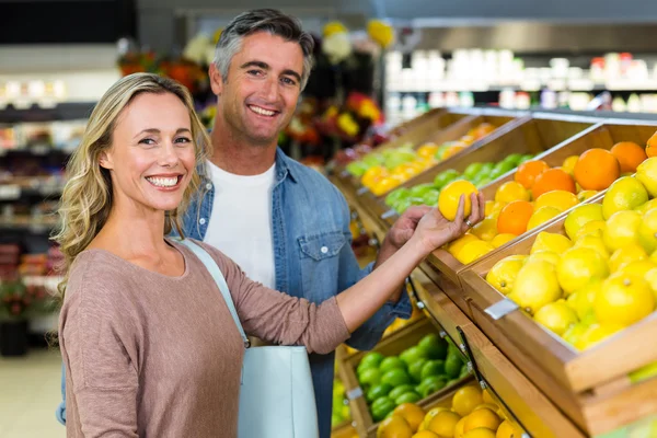 Feliz sorrindo casal escolhendo laranja — Fotografia de Stock