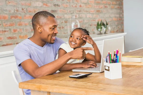 Leuke dochter met behulp van laptop aan bureau met vader — Stockfoto